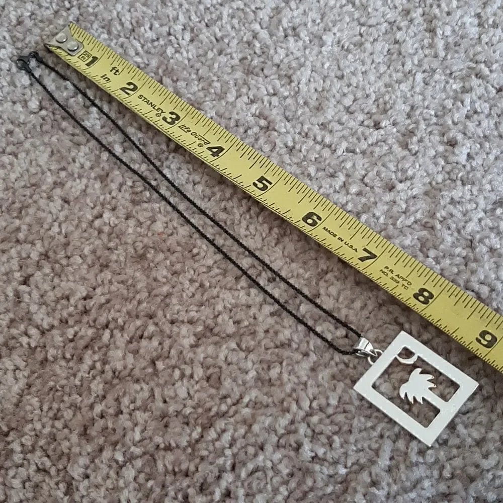 Vintage necklace with silver toned pendant with palm tree and gold half moon